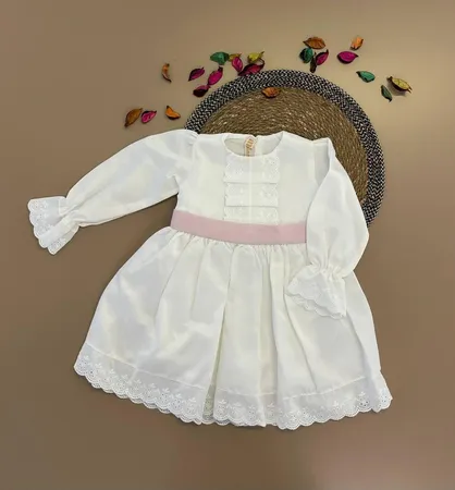 فستان ابيض مع لمسات زهريه وببيونه في الخلف 